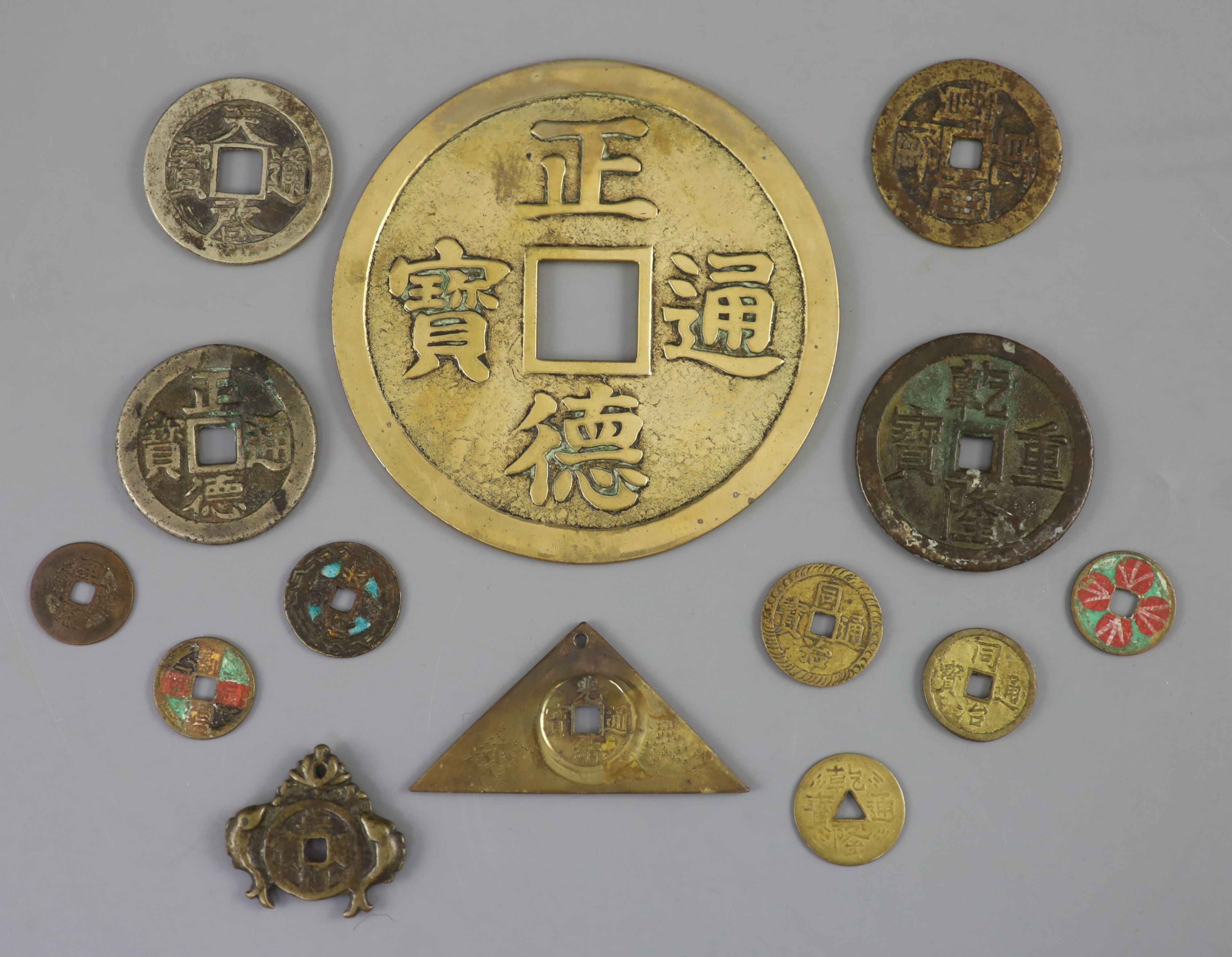 China, a group of 14 bronze and brass coin charms or amulets, Qing to Republic period, F to VF